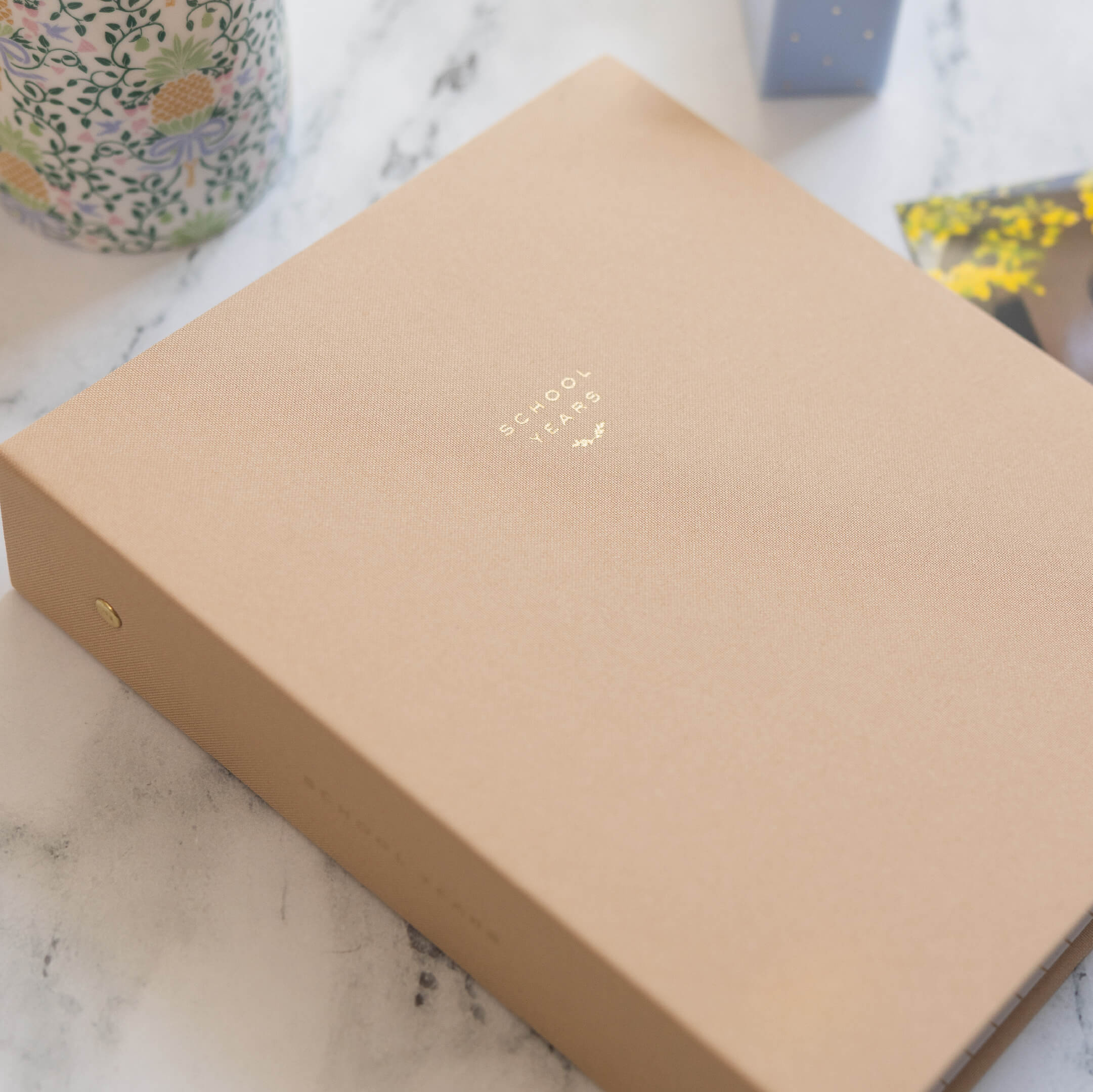 Fawn linen School Years Book on a marble counter.