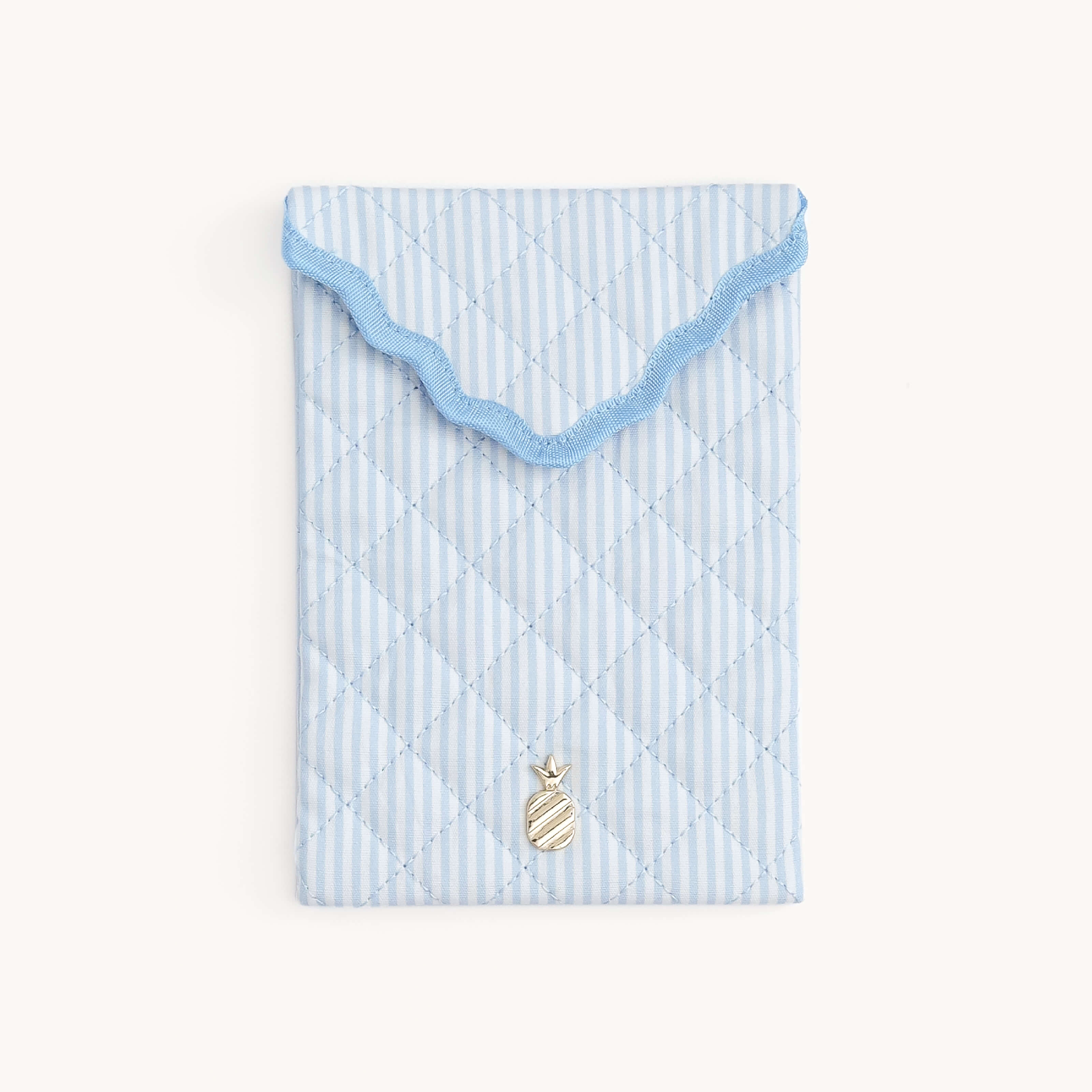 Light blue Blue Pinstripe Quilted E-Reader Case with a gold pineapple charm on a white background