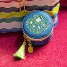 Navy floral round jewelry travel case with tassel zipper pull by Simplified by Emily Ley next to Train Case set