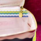 Side view of pastel rainbow wavy stripe travel makeup bag – structured cosmetic organizer with top carry handle