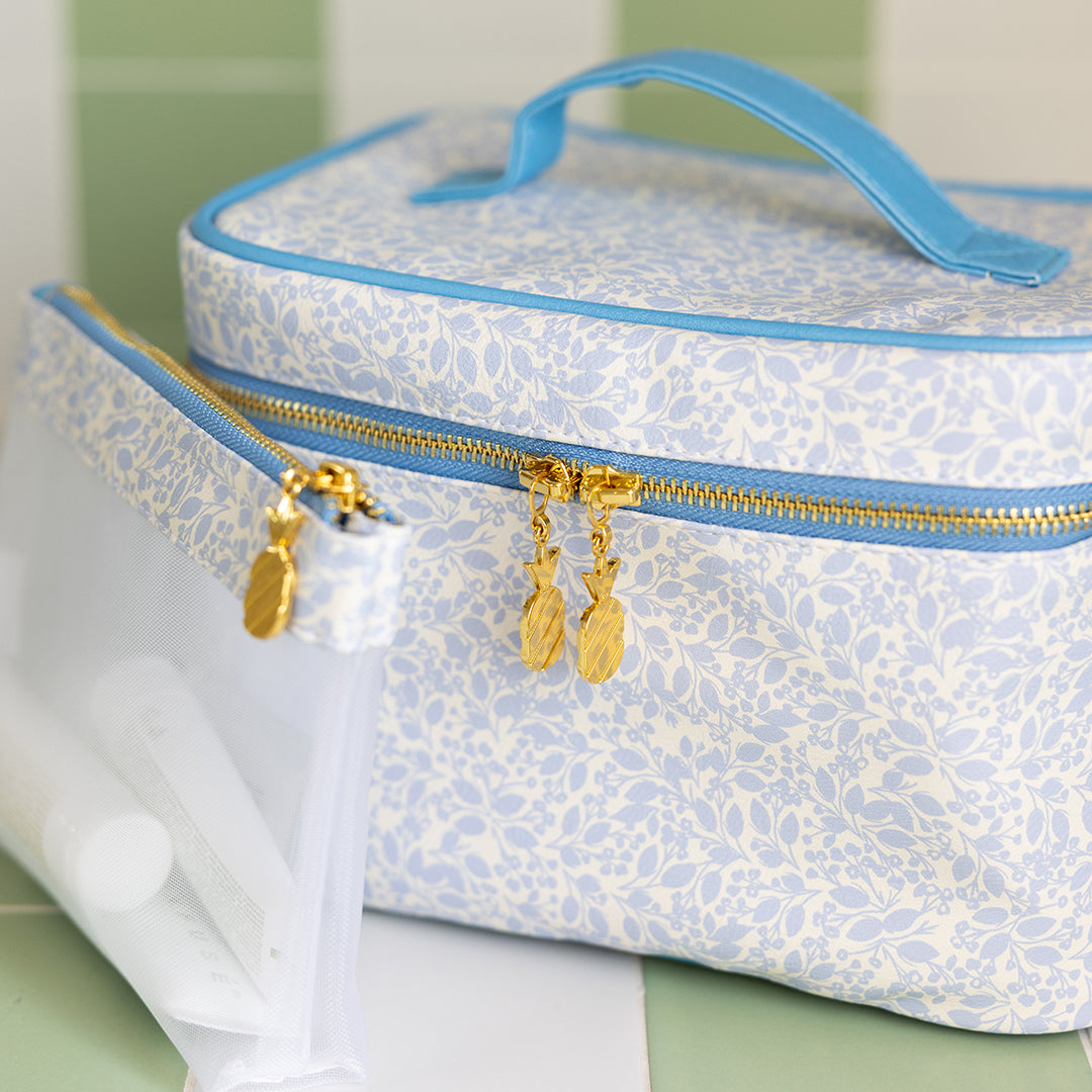 Blue floral makeup organizer with gold hardware on vanity by Simplified by Emily Ley