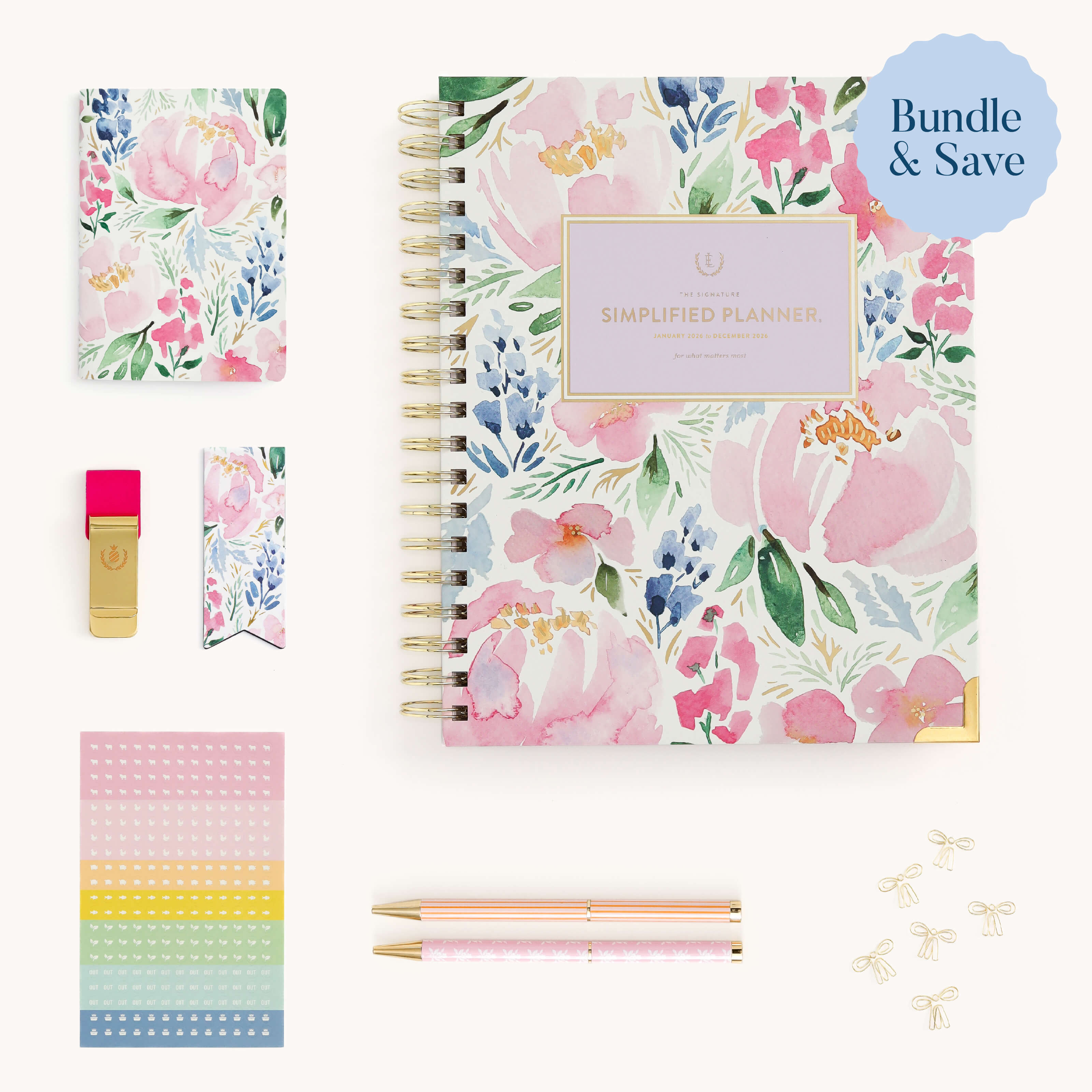 The Weekly Simplified Planner Ultimate Bundle by Simplified® by Emily Ley features a floral-themed spiral planner, small notebook, gold clip, bookmark, colorful sticky notes, two pens, and gold paper clips on a white background.