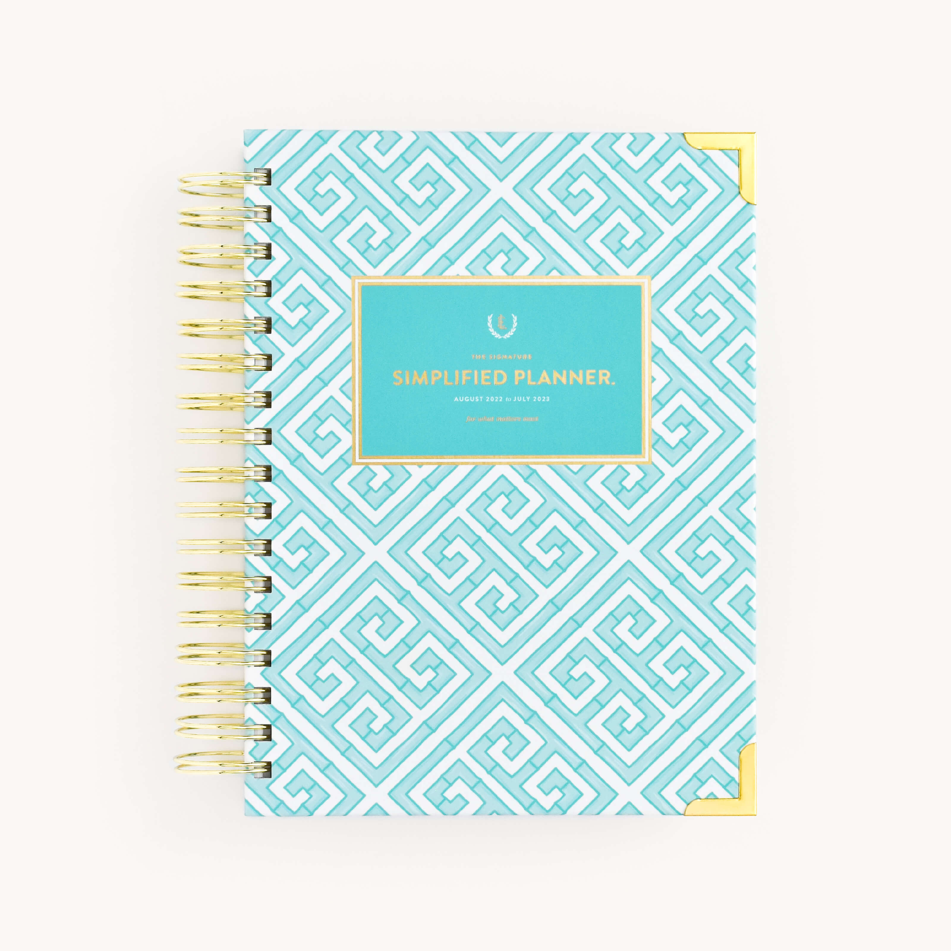 The WS - 2023 Daily, Simplified Planner, Mint Mandalay by Simplified® by Emily Ley features a blue and white geometric cover with gold corner accents and a turquoise label reading "Simplified Planner" in gold.